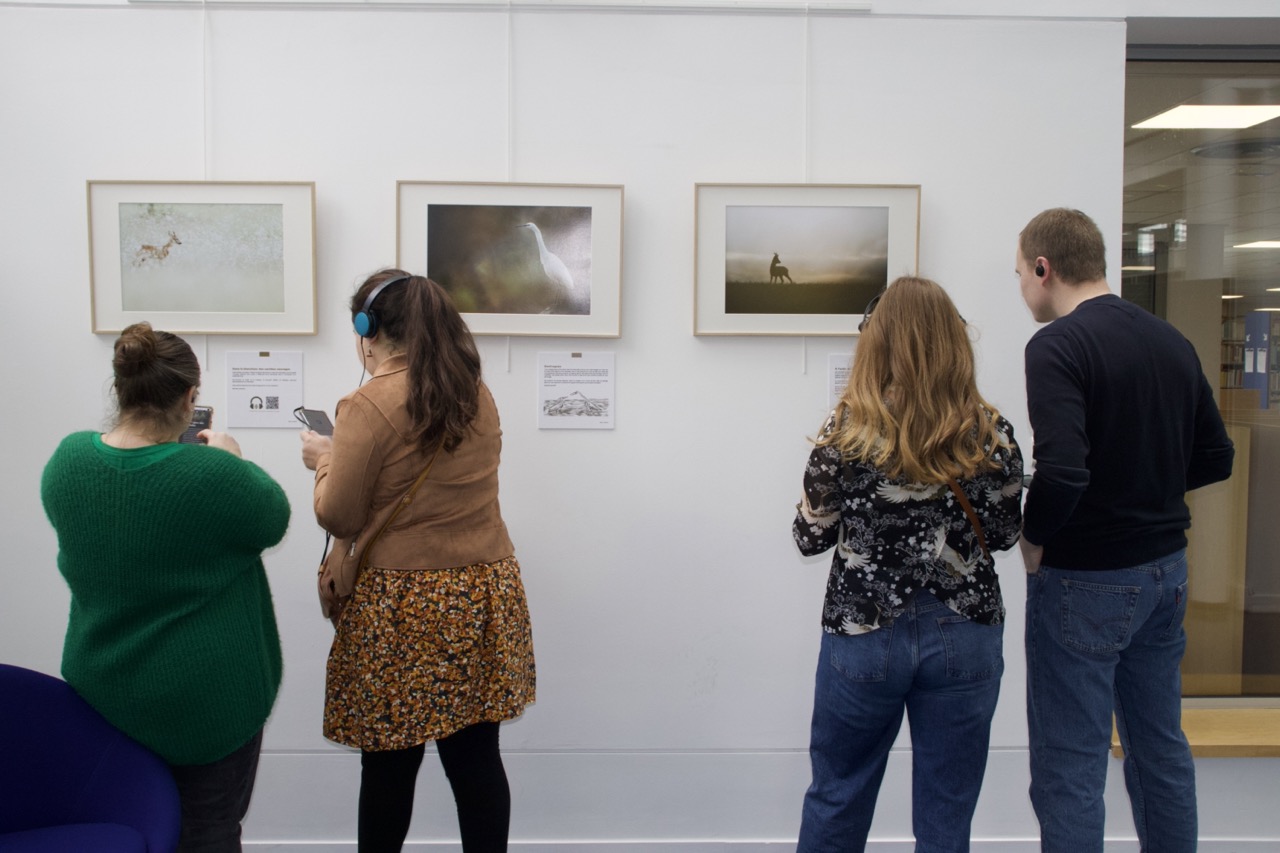 Visiteurs devant l'exposition de photographies Nature Habitée.