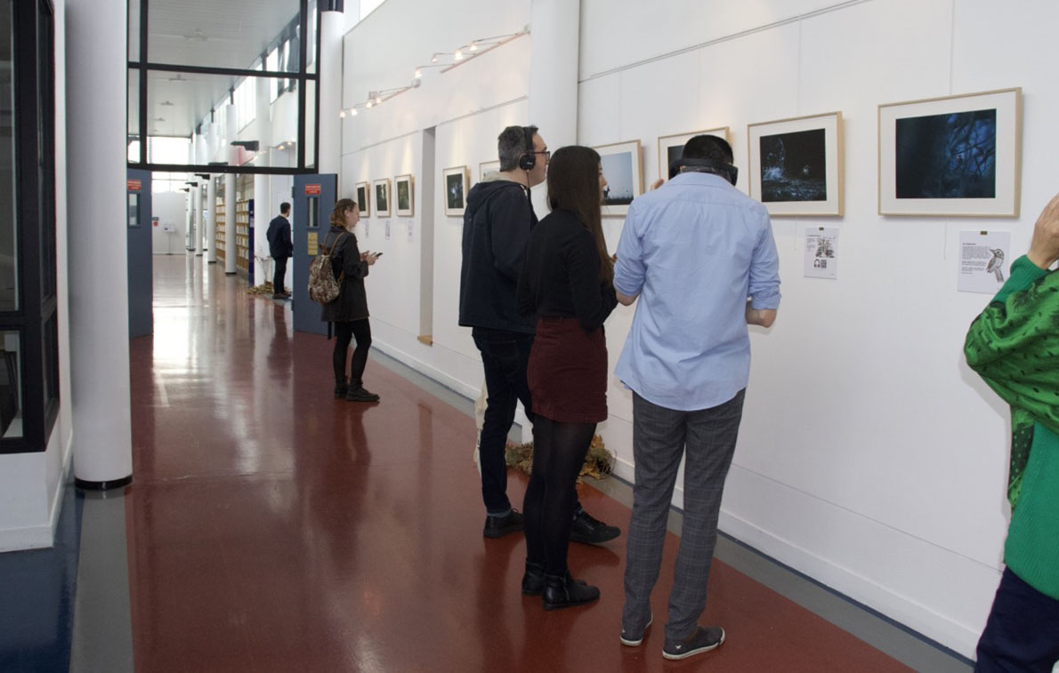 Visiteurs devant l'exposition de photographies Nature Habitée.